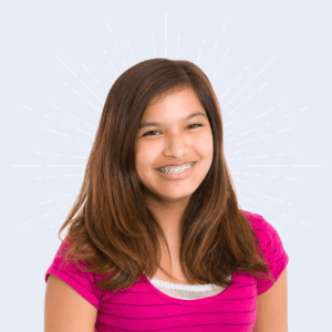 Shot of smiling girl with braces. She's wearing a pink short sleeved shirt.